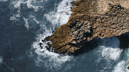 ocean waves hit the rock, topshot aerial view in Portugalの写真素材