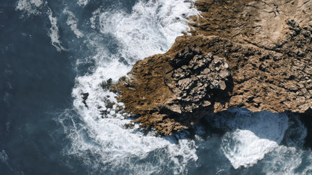 ocean waves hit the rock, topshot aerial view in Portugalの写真素材