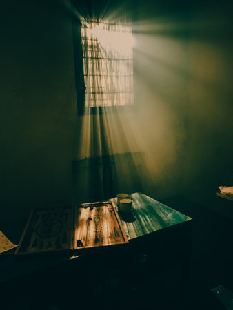 prison life. prison leisure. the suns rays from the prison bars. backgammon game in prisonの写真素材