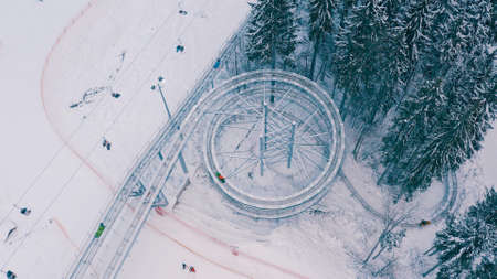 Speed Fun rodelbahn in the forested area in mountains. ski resort on winter daytime Background of spruce forest in snow. Concept of active, extreme winter recreation in mountains.Top Shot. 4Kの写真素材