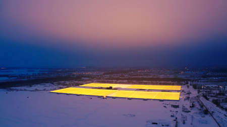 Aerial side view of large industrial greenhouses for growing plants in winter. light pollution....