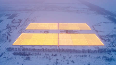 Aerial side view of large industrial greenhouses for growing plants in winter. light pollution....