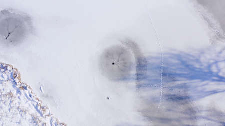 Round hole in a frozen lake. a natural hole from an underwater spring that prevents ice from...