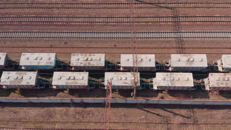 Railway hub showing old crusty freight cars , trains on tracks next to each other top down view drone moving railway tracks positioned parallel. Old Railway Carriages and Wagonsの写真素材
