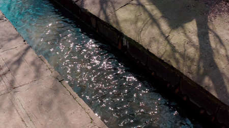 nature is surrounded in the city, the river is walled up in a concrete channel. a daytime river into which chemical waste is dumped. water concrete reservoir in the city. Cityscape 4k Aerial Flightの写真素材