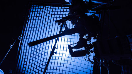 movie camera with macro lens on the slider in the backlight from the frame with grid, the rays of...