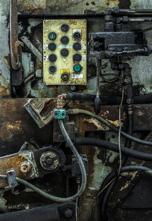 Machine control panel with a lot of buttons among the mechanisms, hoses and levers.の写真素材