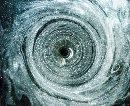 White paint in the water moves in a spiral. Galactic artの写真素材