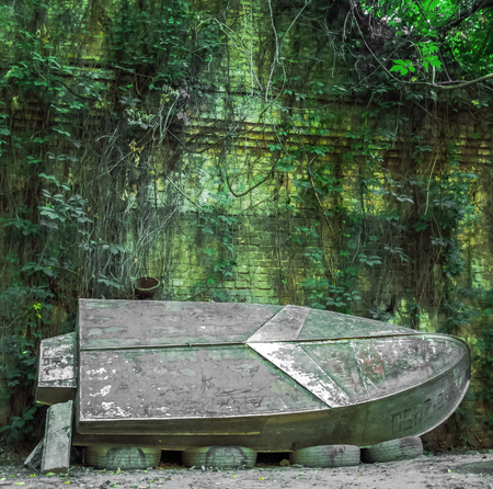 An old boat on the river bank. Reflection of trees in the water.の写真素材