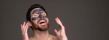 Banner view of shirtless man with clay mask laughing isolated on grey background