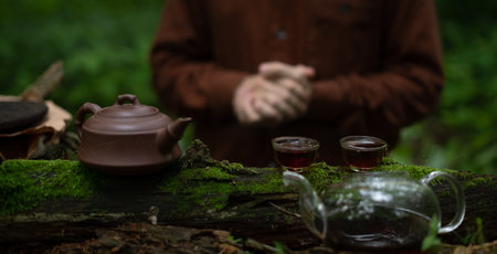 Puer tea in clay teapot near man in forestの写真素材