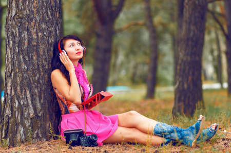 Beautiful girl listening to music on headphones. Young woman listening to musicの写真素材