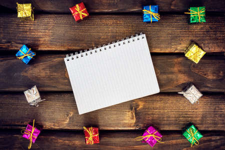 Boxes with gifts on a dark wooden boards. White notepad. Happy new year. Space for text. Old background. New Year background.の写真素材