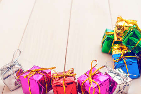 Boxes with gifts on a light wooden boards. White notepad. Happy new year. Space for text. Old background. New Year background.の写真素材