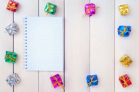Boxes with gifts on a light wooden boards. White notepad. Happy new year. Space for text. Old background. New Year background.の写真素材