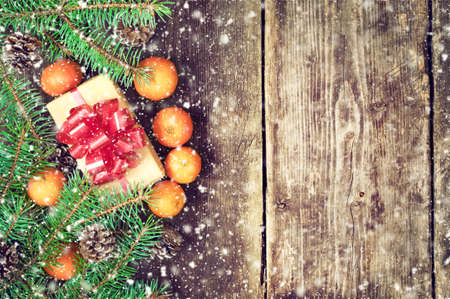 Branches of a Christmas tree on old boards. Christmas background. Christmas Socks. Christmas decorations. New Year background. Xmax background. Toned image. Falling Snow.の写真素材