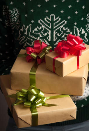 Christmas gifts. Knitted mittens. Woman holding a gifs. Knitted dress. Box with gifts. Present....