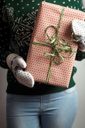 Christmas gifts. Knitted mittens. Woman holding a gift. Knitted dress. Box with gifts. Present....