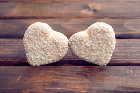 Cookies in the shape of heart. Cookies, white chocolate with coconut struzhkoy.Pechene heart on a wooden background.の写真素材