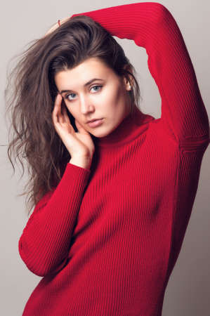 Beautiful young woman. Young girl. Girl in red knitted dress. Beauty portrait.  Girl portrait on a...