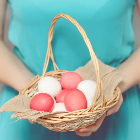 Easter Egg. Girl holding a basket with Easter eggs. Easter eggs lying in a basket. Easter ideas. Happy easter.Toned image.の写真素材