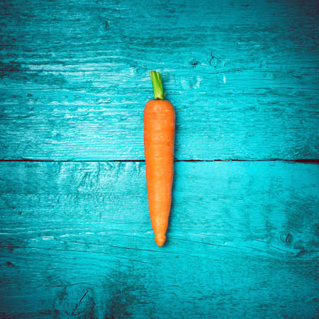 Carrot on the old blue wooden boards. Bright carrots. Toned image. Selective focus.の写真素材