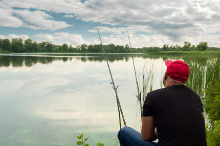 Man catches a fish in a pond. Fishing.の写真素材
