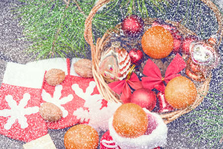 Christmas decorations lay in a wicker basket. Merry Christmas. Christmas background. Christmas Socks. 2017 year. Christmas decorations. New Year background. Xmax background. Toned image. Snow falls.の写真素材