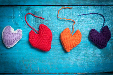 Valentine's Day. Colorful knitted hearts. Red heart on the blue boards. Valentines day. Heart pendant. Red heart. Valentine cards. Space for text. Eighth of March. International Women's Day.の写真素材