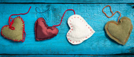 Valentine's Day. Colorful knitted hearts. Red heart on the blue boards. Valentines day. Heart pendant. Red heart. Valentine cards. Letter box look. Eighth of March. International Women's Day.の写真素材