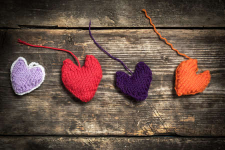 Valentine's Day. Colorful knitted hearts. Red heart on the dark old boards. Valentines day. Heart...