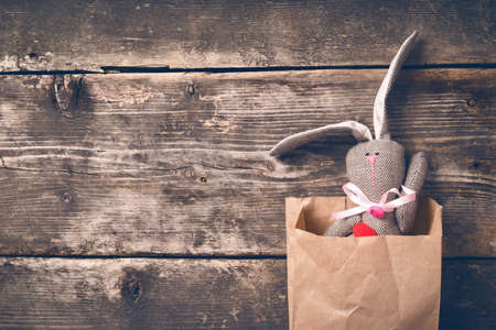Easter bunny in a paper bag on old boardsの写真素材