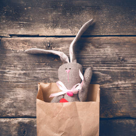 Easter bunny in a paper bag on old boardsの写真素材