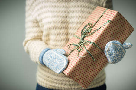 A girl holding a box with a Christmas presentの写真素材