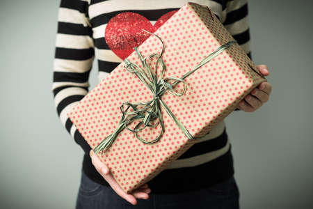A girl holding a box with a Christmas present