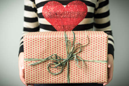 A girl holding a box with a Christmas present