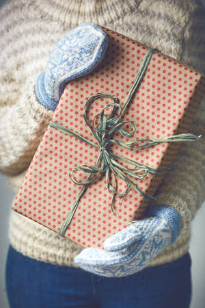 A girl holding a box with a Christmas present