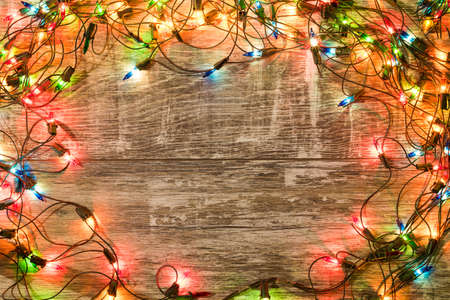 Christmas holiday background. Christmas lights lie on dark, old boards. New Year background....