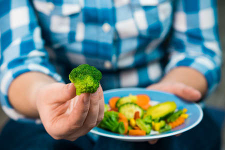 Girl with a plate of vegetables in handsの写真素材
