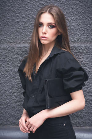 Beautiful girl on a black wall backgroundの写真素材