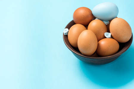 Easter eggs of brown color lie in a dark clay plate