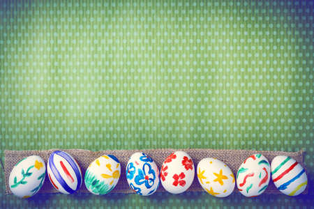 Painted Easter eggs on a green background with white polka dots. Toned image. Beautiful holiday...