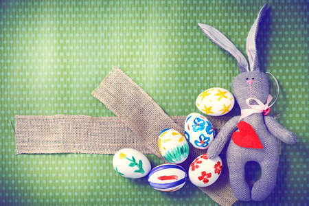 Painted Easter eggs on a green background with white polka dots. Toned image. Beautiful holiday card. Space for text. Happy easter.の写真素材