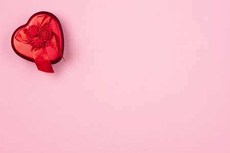 Red heart with a gift to Valentine's Day on a beautiful pink background. Heart pendant. Space for text. Red heart. Valentine Day.の写真素材