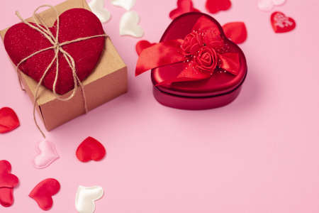 Red hearts with a gift to Valentine's Day on a beautiful pink background. Heart pendant. Space for text. Red heart. Valentine Day.の写真素材