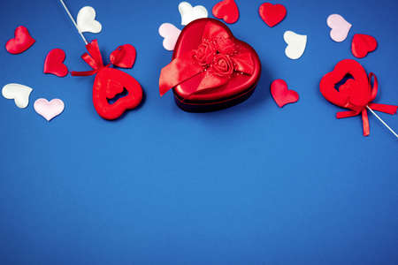 Red heart with a gift to Valentine's Day on a beautiful blue background. Heart pendant. Space for text. Red heart. Valentine Day.の写真素材