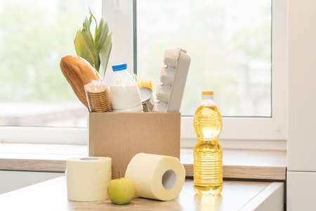 Donation box with food on a light interior background.の写真素材