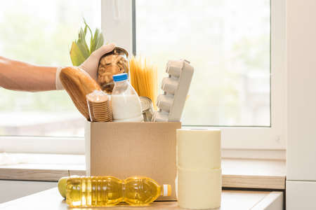 Donation box with food on a light interior background.の写真素材