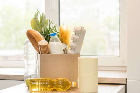 Donation box with food on a light interior background.の写真素材