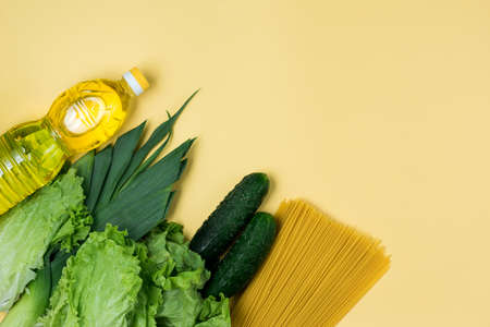 Essential fresh products lie on a yellow background. Greens food. Food delivery covid-19 epidemic, Donation. Top view. Copy space.